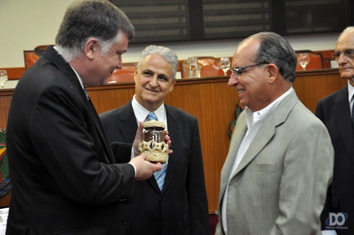 Fernando Cunha entrega um frasco ornamentado com trançado estrela e com terra de Olímpia