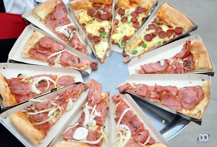 Fatias de diversos sabores sendo servidas aos convidados e presentes