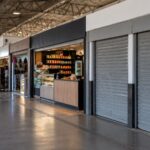 Boxes comerciais da Rodoviária Paschoal Lamana, em Olímpia, com lojas abertas e dois boxes de portas fechadas