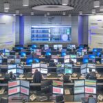 Sala do Centro de Operações Integrado da CPFL, com operadores diante de painéis e dezenas de telas