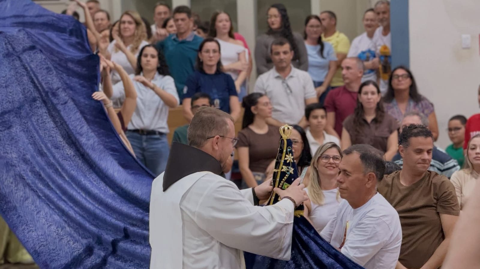 Frei segura a imagem de Nossa Senhora Aparecida diante de fiéis durante celebração no Santuário de Olímpia