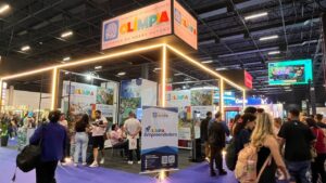 Estande de Olímpia em edição anterior da Feira do Empreendedor, com banner do programa Olímpia Empreendedora e visitantes conversando