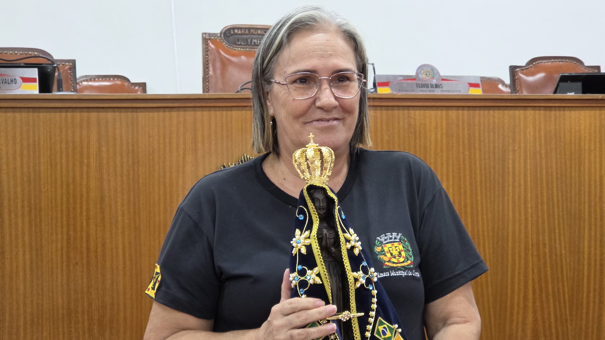 Servidora da Câmara Municipal de Olímpia segura a imagem de Nossa Senhora Aparecida