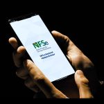 Mãos seguram um celular com a tela inicial do NFS-e Nacional, Módulo Emissor