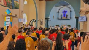 Fiéis de braços erguidos durante celebração no Santuário Nossa Senhora Aparecida, em Olímpia