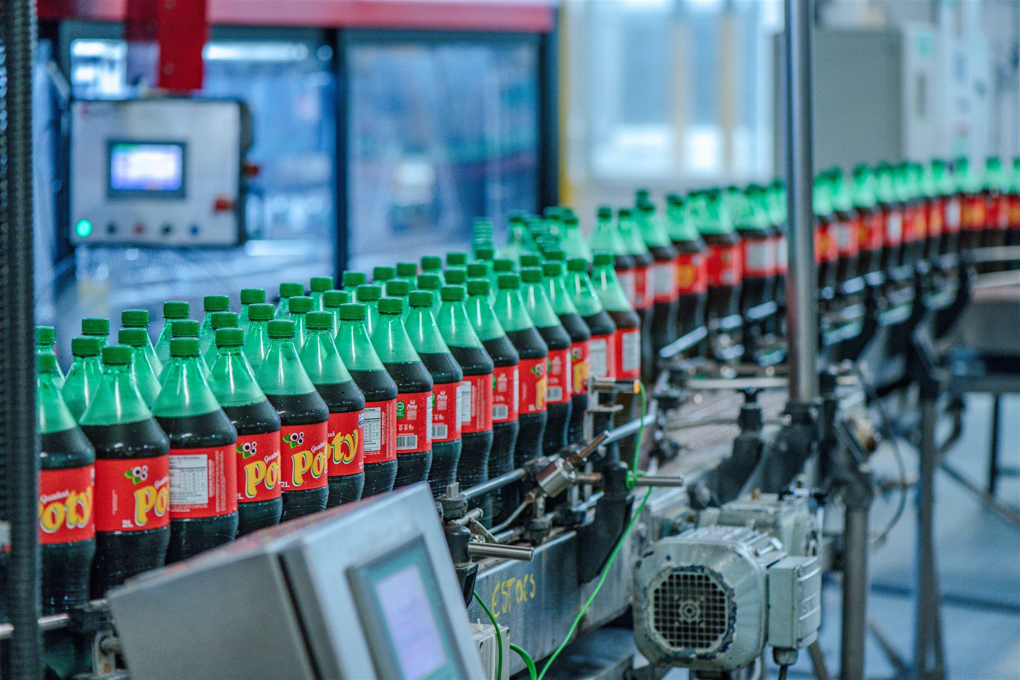 Garrafas de Guaraná Poty de 2 litros em esteira curva na linha de envase da fábrica