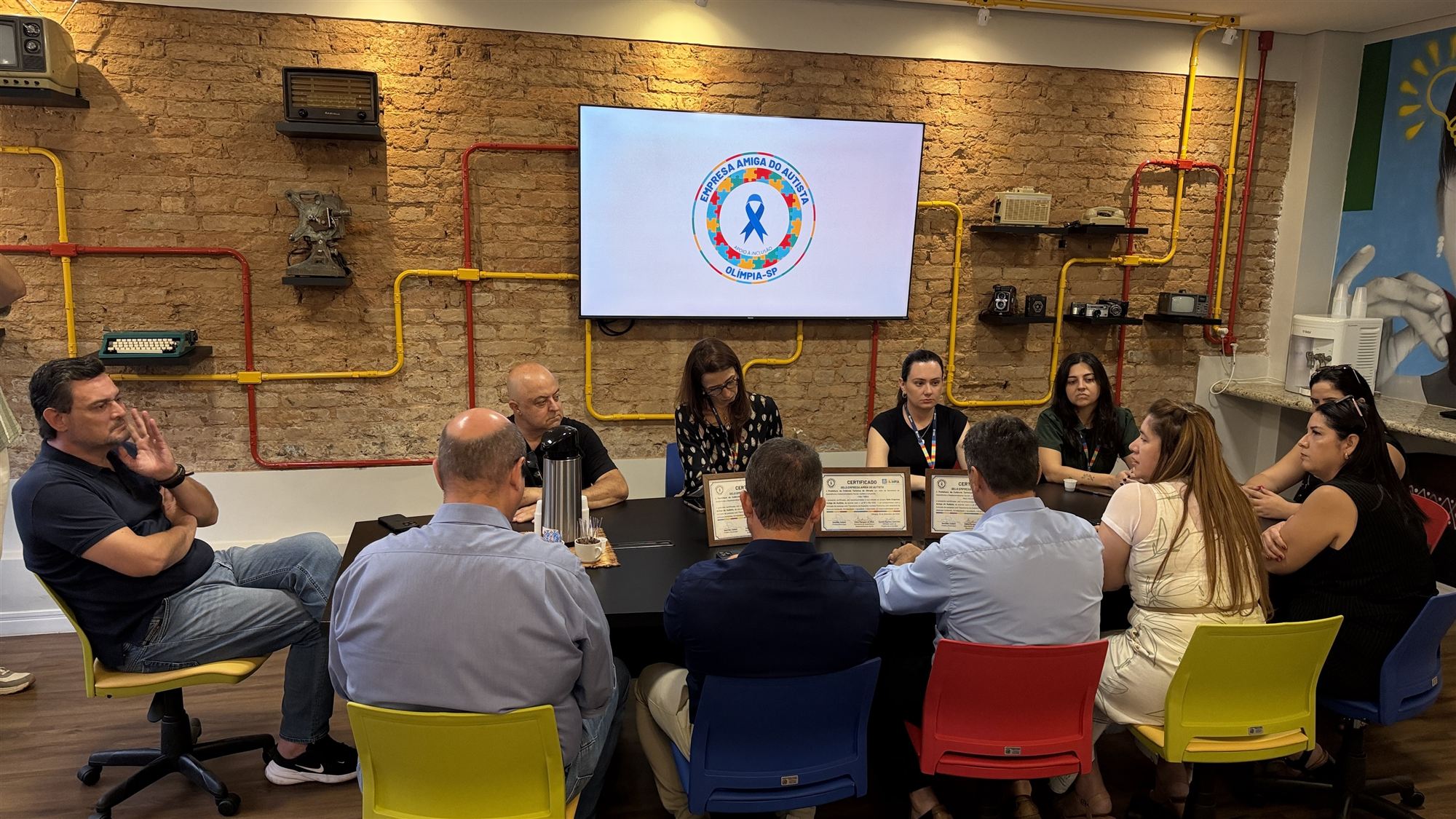 Reunião em mesa preta com representantes das empresas e da Prefeitura durante a entrega do selo Empresa Amiga do Autista
