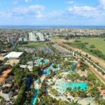 Vista aérea de Olímpia com parque aquático em primeiro plano, prédios ao fundo e área verde ao lado